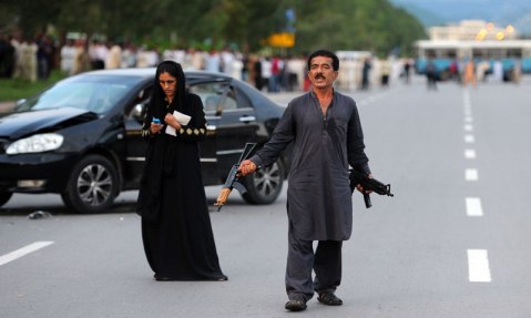 Muhammad Sikandar stands next to his wife during a standoff with police in Islamabad on August 15, 2013. — Photo by AFP